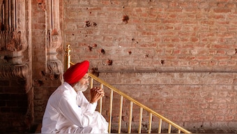 (File) A Sikh man sits beside the wall of one of the complex of Golden Temple hit by the bullet shots during the operation Blue Star in Amritsar, Reuters